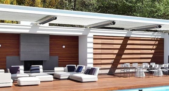 radtec heaters installed on the overhang of a sunny outdoor pool with white outdoor patio furniture and a brown wooden deck